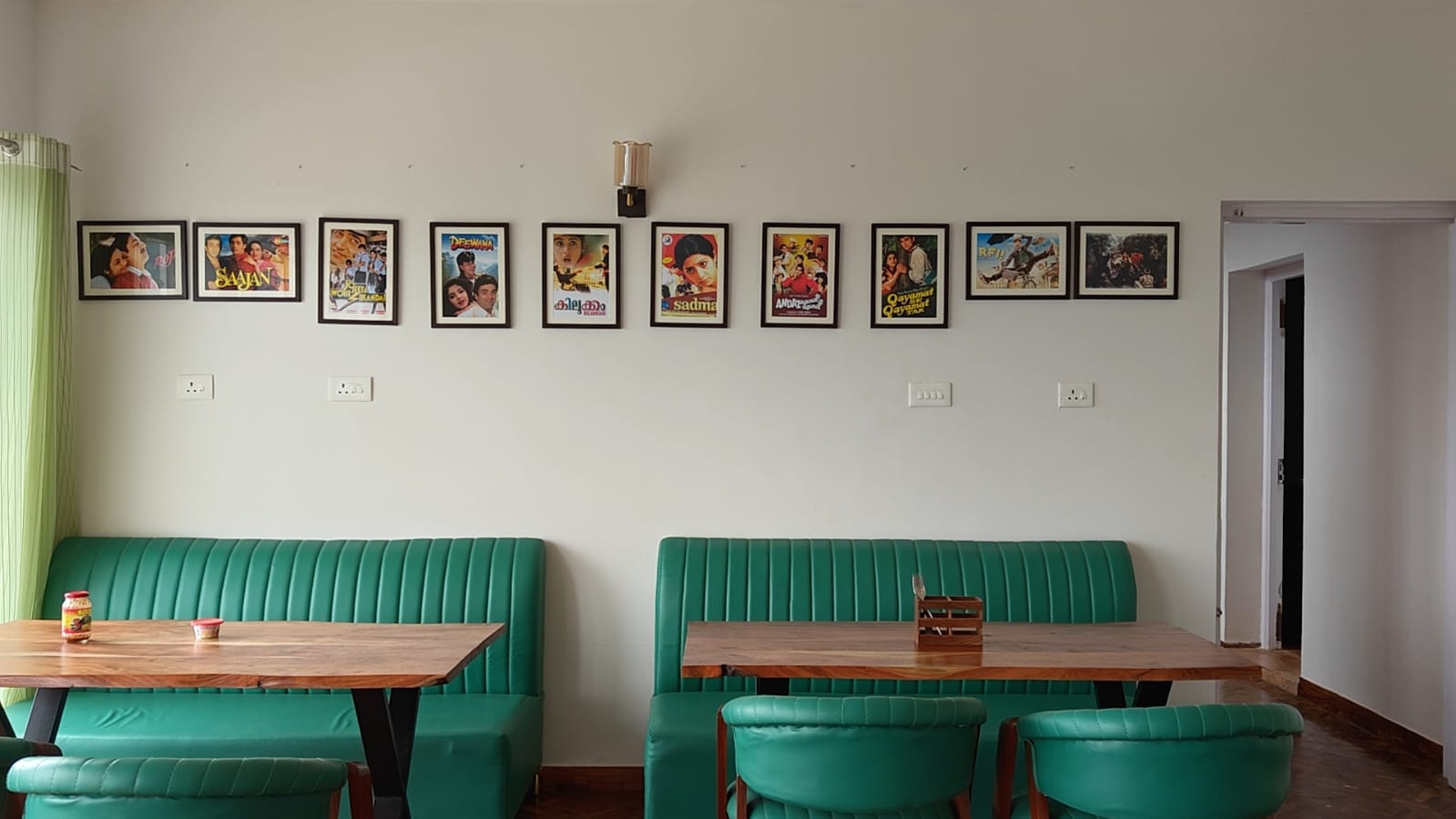 The dining room, green banquettes along a wall hung with framed classic film posters