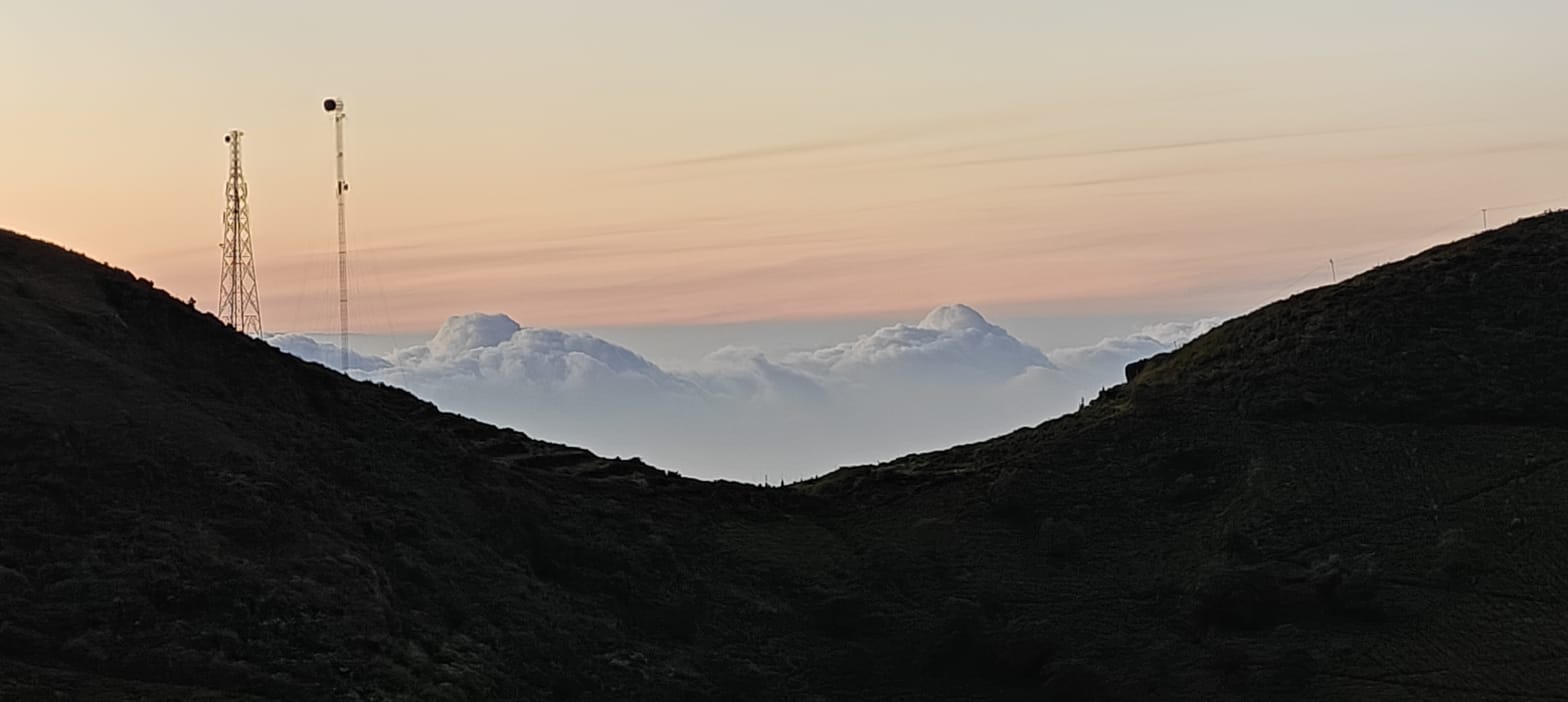 Sunrise light spreading over the hills, radio masts silhouetted on the ridge