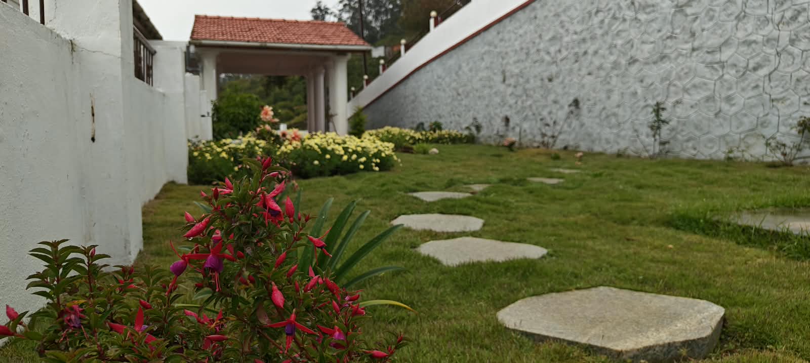 The upper lawn bordered with flower beds, the house behind it